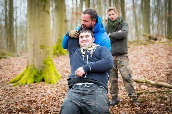 Zwei Personen üben eine Technik zur Kontrolle in einem Waldgebiet aus