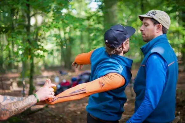 Zwei Personen in blauen Jacken üben eine Technik zur Kontrolle des Arms