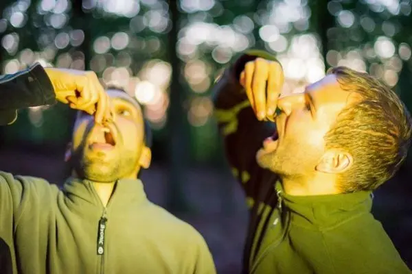 Zwei Personen nehmen etwas mit den Fingern in den Mund
