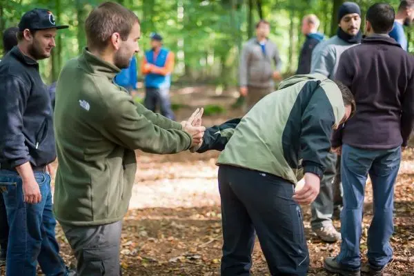 Zwei Personen üben eine Technik zur Kontrolle in einem Waldgebiet