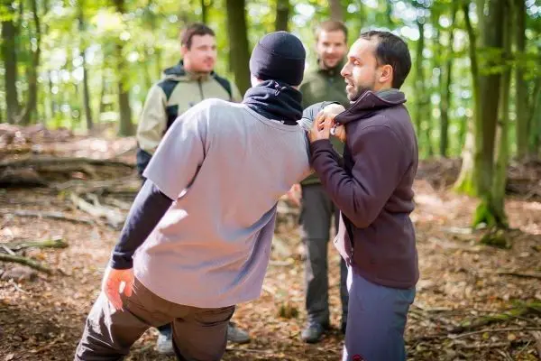 Zwei Personen üben eine Technik zur Kontrolle in einem Waldgebiet