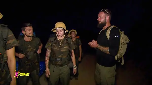 Gruppe in Tarnkleidung steht im Dunkeln, diskutiert und bereitet sich vor