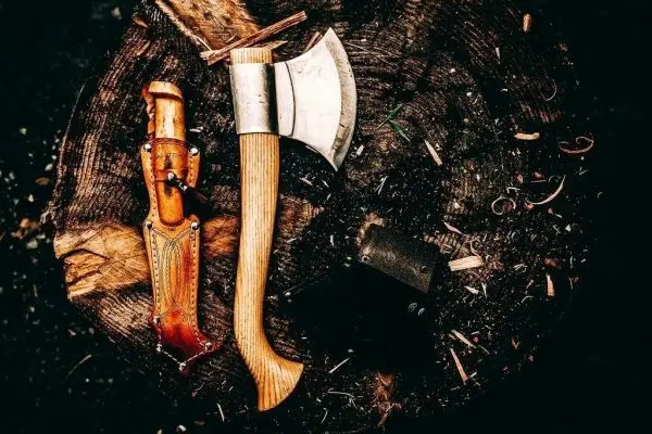 Axt und Messer auf einem Holzscheit
