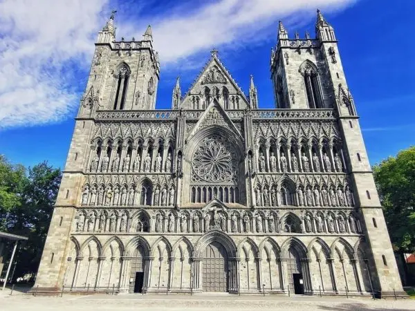 Große Kathedrale mit detaillierter Fassade und Rosette unter blauem Himmel