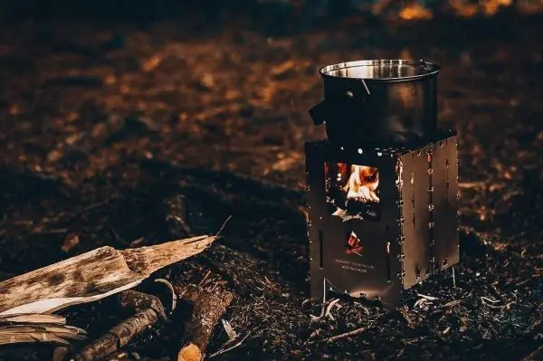 Hobo-Kocher mit Topf und Flamme auf dem Boden