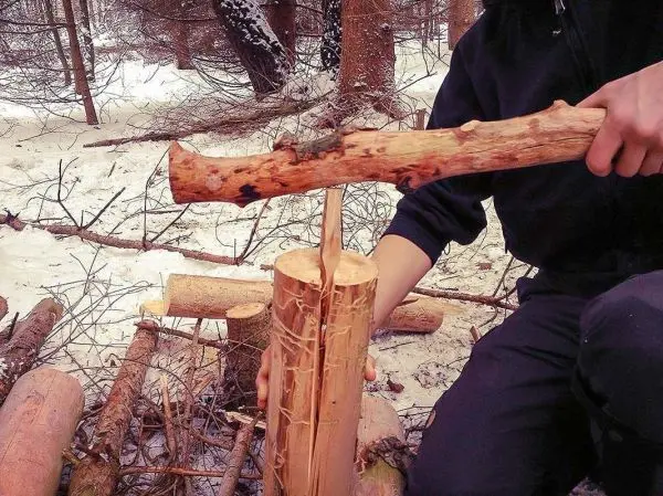 Holzstück wird mit einem Stock bearbeitet, um es zu spalten