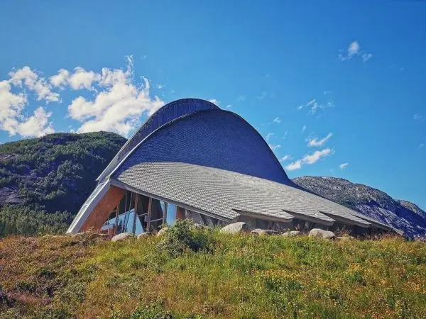 Moderne Architektur mit geschwungenem Dach in einer grünen Landschaft