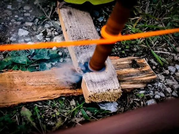 Rauchentwicklung an Holzstück durch Reibung mit Schnur