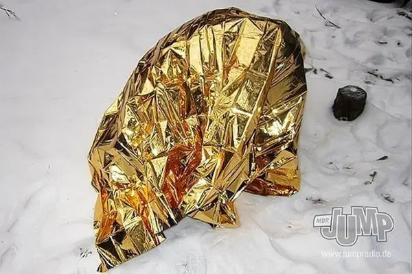 Reflektierende Rettungsdecke liegt auf Schnee