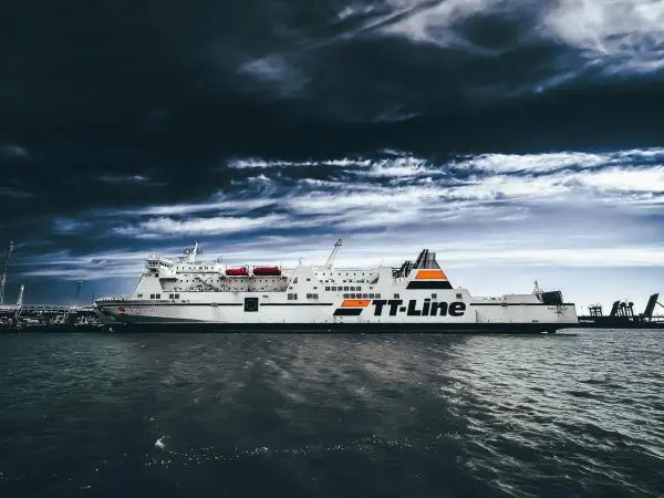 Fähre von TT-Line liegt im Hafen, umgeben von Wasser und bewölktem Himmel