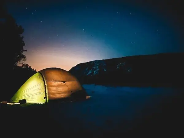 Zelt leuchtet in der Dunkelheit unter einem sternenklaren Himmel