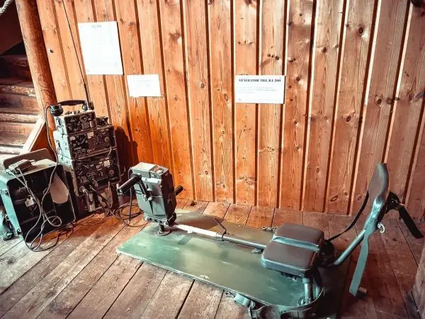 Gerät mit Sitzfläche und Steuerung auf Holzfußboden neben technischen Geräten