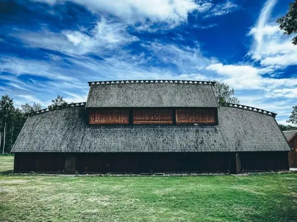 Holzgebäude mit einem großen, geschwungenen Dach und Fenstern im oberen Bereich