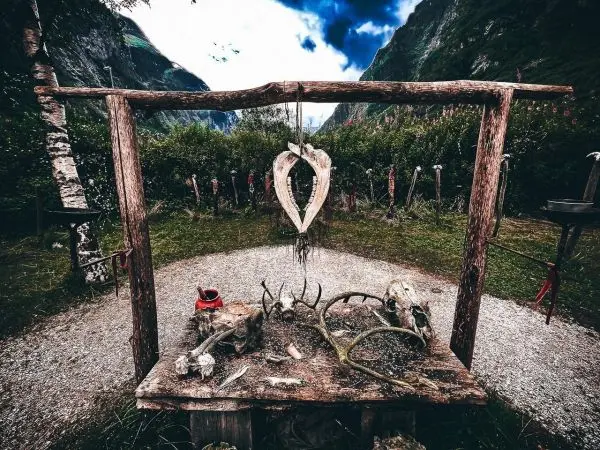 Holzgestell mit Tierknochen und einem herzförmigen Ornament in einer natürlichen Umgebung