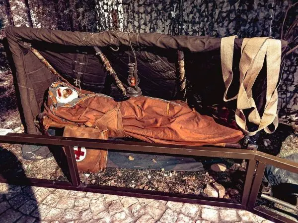 Improvisierte Trage mit einer Person in einem Schlafsack und medizinischer Ausrüstung