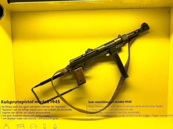 Maschinenpistole Modell 1945 auf gelbem Hintergrund, mit abnehmbarer Schulterstütze und Abzug