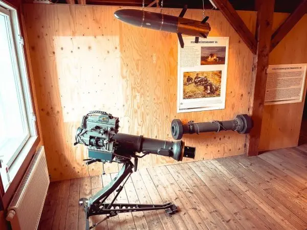 Militärische Ausrüstung mit einem Geschütz und einer hängenden Rakete an der Wand