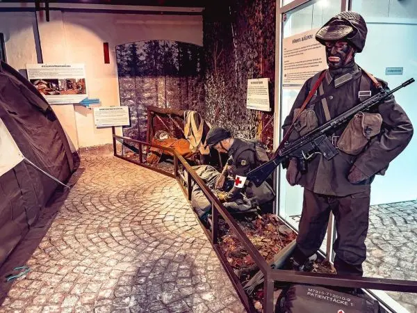 Militärische Ausstellung mit Soldatenfiguren, Zelt und Ausrüstung auf dem Boden