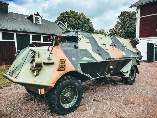 Militärisches Fahrzeug mit Tarnmuster steht auf einem Schotterplatz