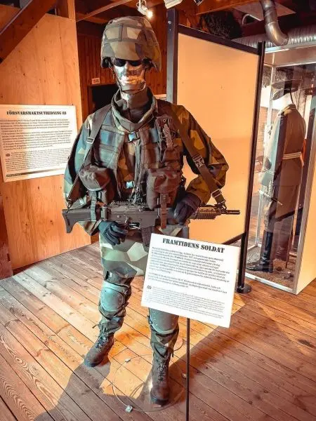 Soldatenfigur in Tarnkleidung mit Gewehr in der Hand, ausgestellt in einem Museum