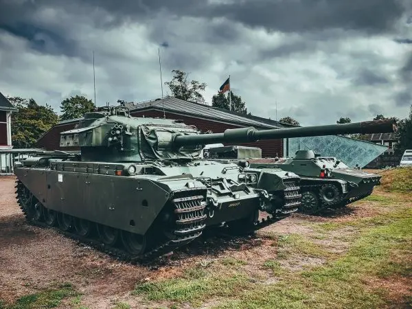 Zwei Militärfahrzeuge stehen auf einem Platz, eines mit großem Geschütz