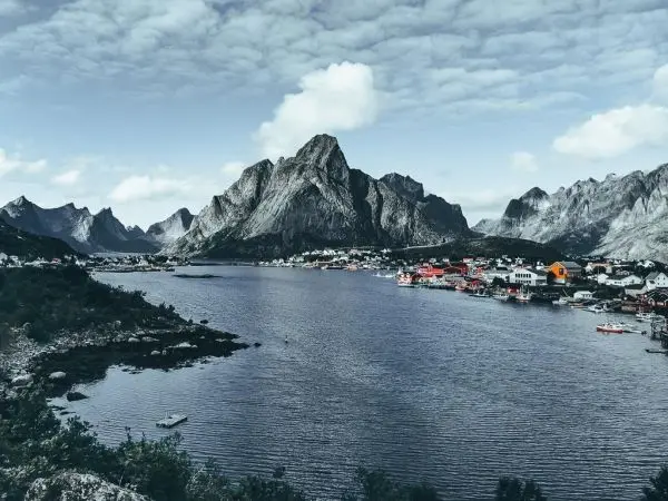 Bergige Küstenlandschaft mit Wasser und bunten Häusern am Ufer
