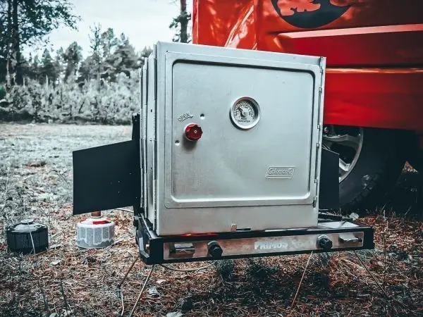Campingkocher mit seitlichen Flügeln und Druckanzeige auf einem Ständer