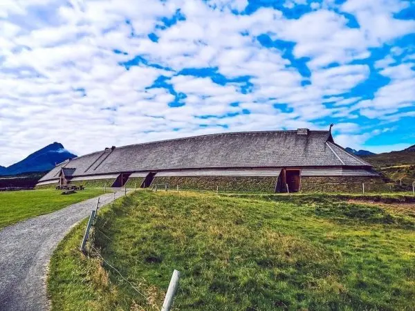 Großes, traditionelles Gebäude mit einem geschwungenen Dach in einer grünen Landschaft