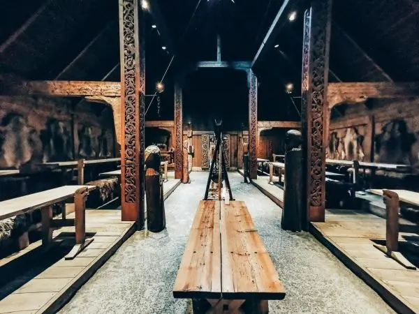 Holzbank und Tische in einem historischen Raum mit geschnitzten Wänden