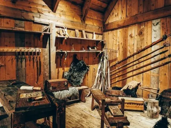 Holzraum mit Werkzeugen, Möbeln und Jagdausrüstung an Wänden und Tischen