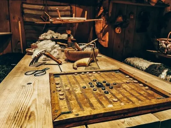 Holztisch mit Spielbrett und verschiedenen Werkzeugen