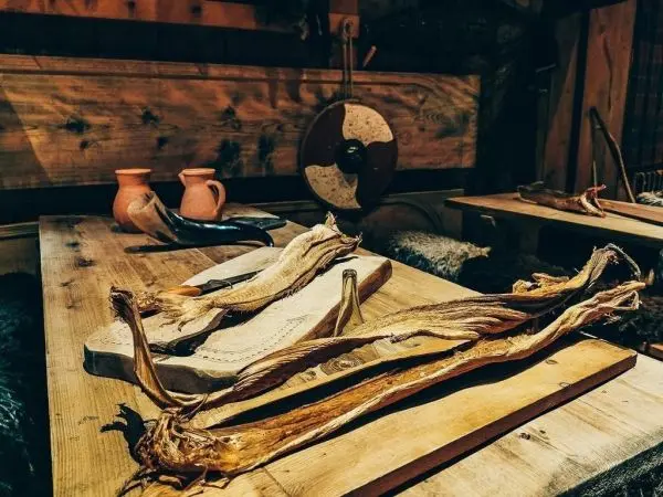 Trockenfisch und Holzbrett liegen auf einem Holztisch in einer rustikalen Umgebung