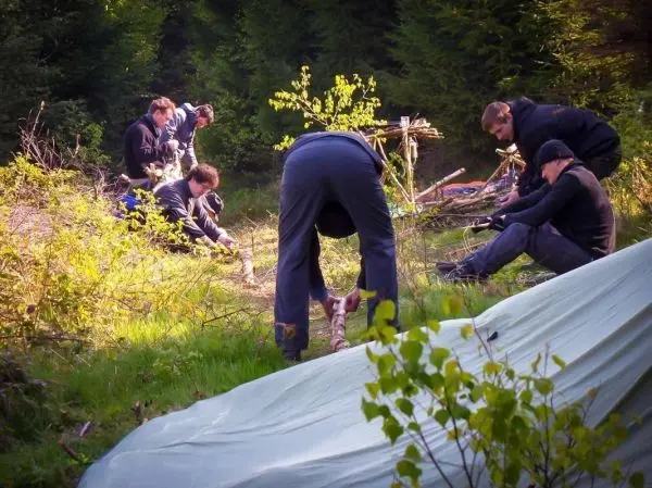 Gruppierung arbeitet im Wald an Holzarbeiten und Konstruktionen