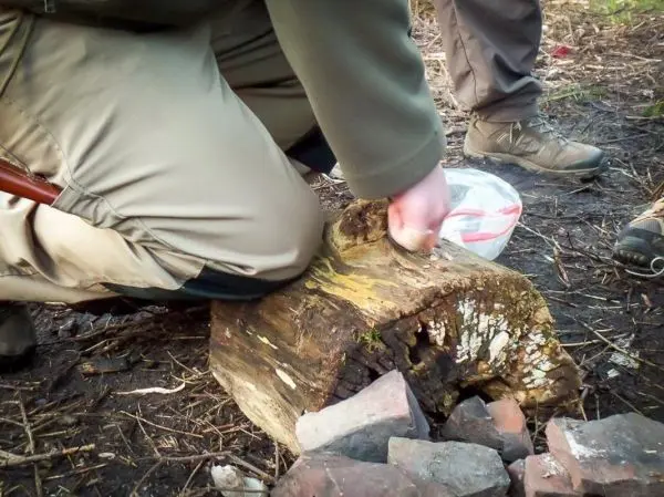 Messer schneidet in einen Holzblock zur Vorbereitung von Zunder