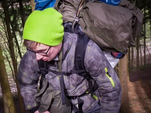 Rucksack mit Ausrüstung wird auf einem Waldweg getragen