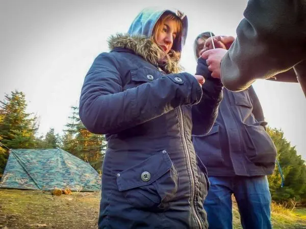 Zwei Personen stehen in der Natur und halten eine Schnur in der Hand