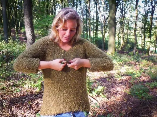 Frau schneidet mit einem Messer Pflanzenmaterial im Wald