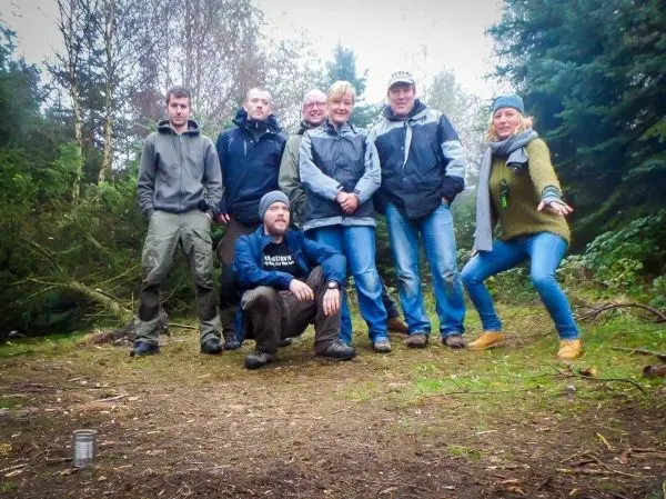 Gruppe von sieben Personen steht im Wald zusammen