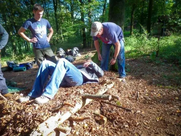 Mann liegt auf dem Boden, während ein anderer ihn untersucht und ein Dritter zuschaut