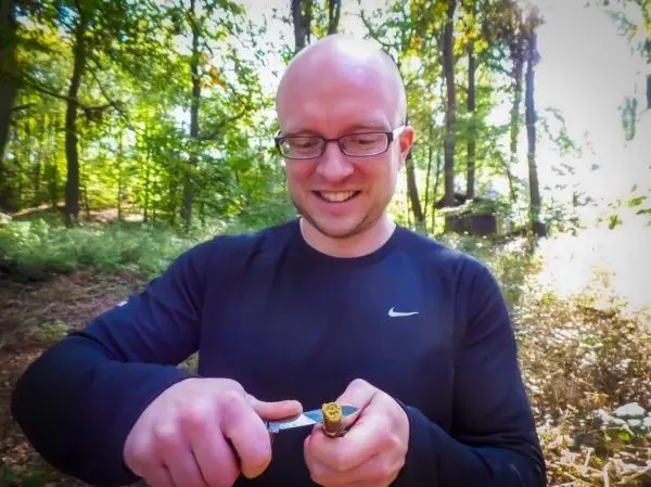 Messer schneidet in einen Holzstock im Wald