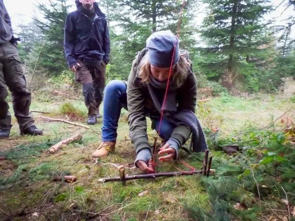 Person baut eine Falle im Wald auf