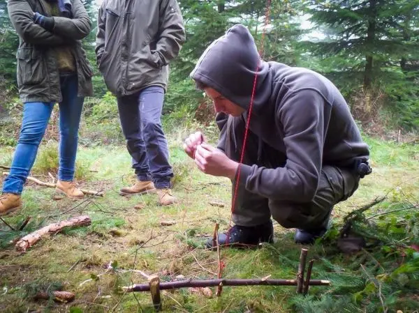 Person knotet eine Schnur an einem selbstgebauten Gerät