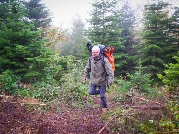 Wanderer mit Rucksack durchquert bewaldetes Gelände