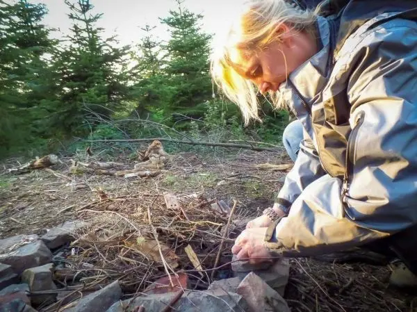 Zunder wird in einer Steinringfeuerstelle vorbereitet