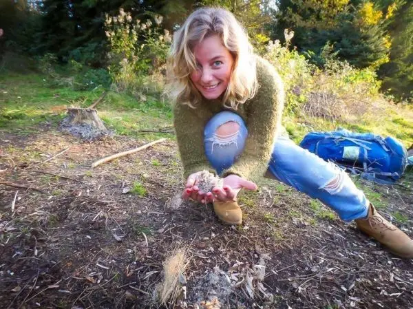 Zunder wird in Händen gehalten und auf den Boden gelegt