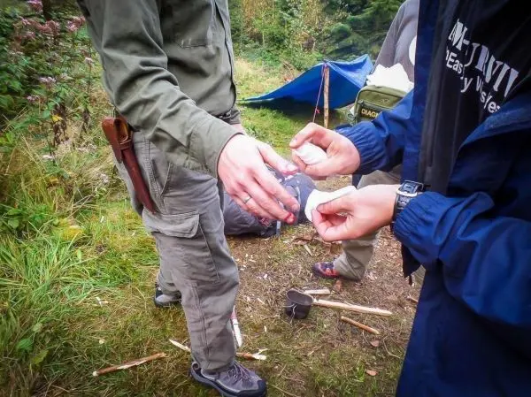 Hände übergeben Zunder zwischen zwei Personen in einem Waldgebiet