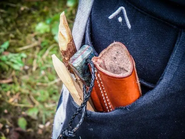 Holzstücke und ein Lederetui stecken in einer Tasche