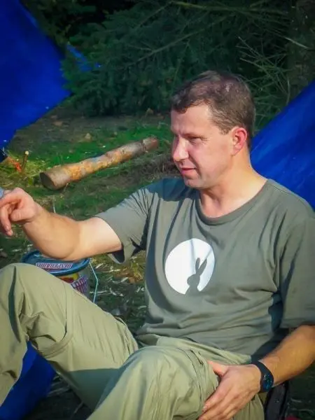 Mann sitzt im Freien und zeigt mit der Hand auf einen Punkt