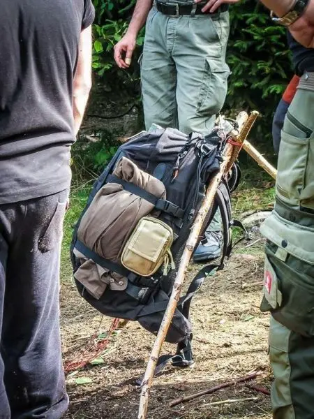 Rucksack lehnt an einem Stock, umgeben von mehreren Personen