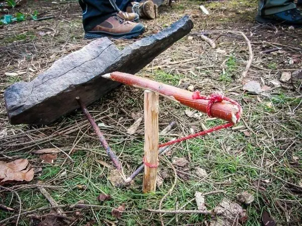 Selbstgebaute Falle aus einem Stein und Holzstöcken im Wald